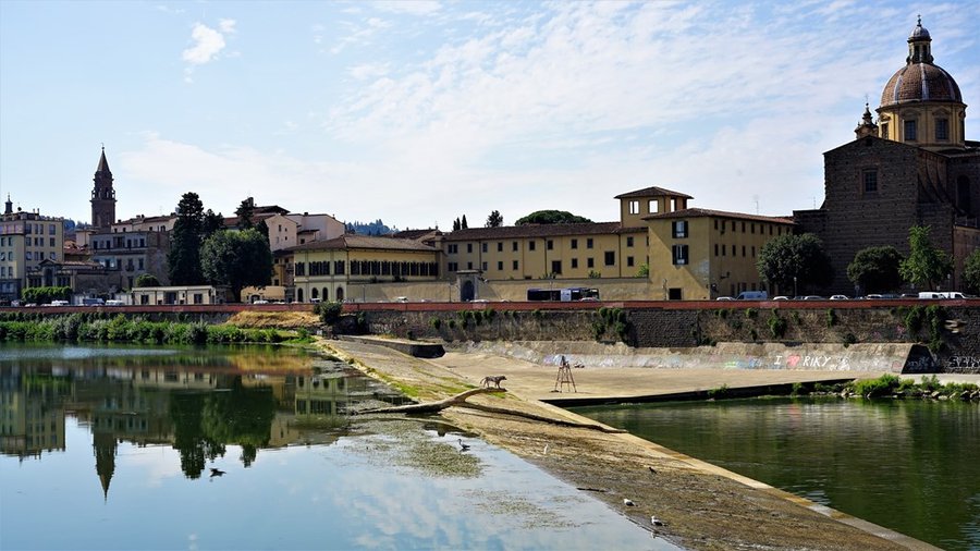 Panorama Florencji nad rzeką Arno w świetle dnia, widoczna kopuła kościoła i zabudowa miasta