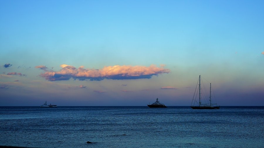Jachty żaglowe na morzu u wybrzeży Giardini-Naxos o zmierzchu
