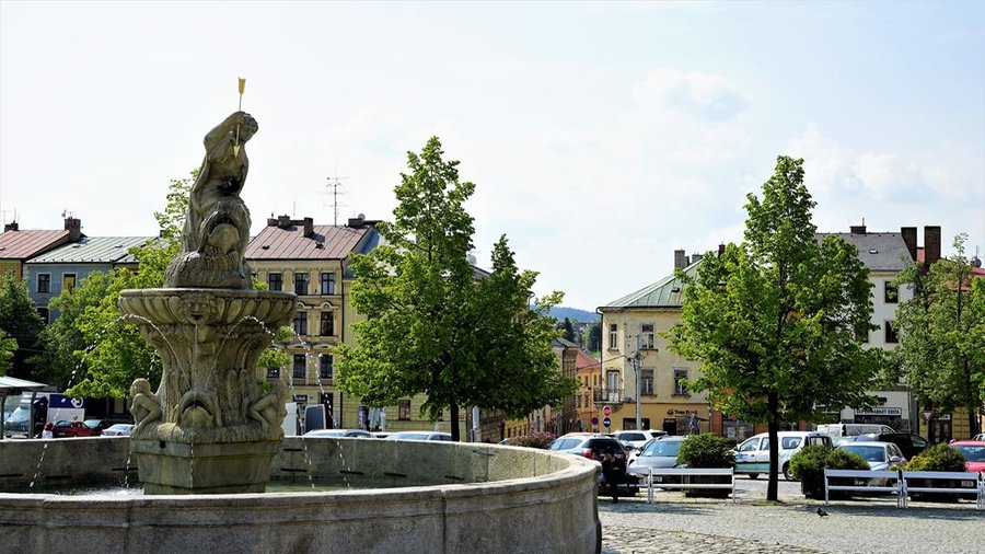 Zabytkowa fontanna z rzeźbą na rynku w Jihlavie, otoczona drzewami