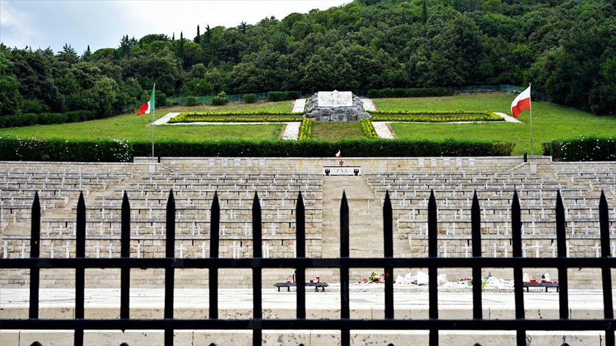 Polski Cmentarz Wojenny na Monte Cassino widziany od frontu, rzędy krzyży i flagi Polski i Włoch