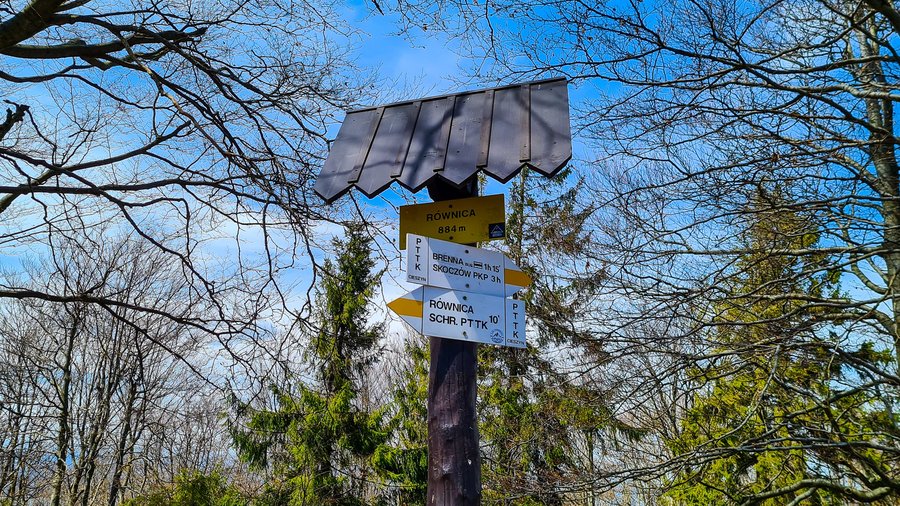 Drogowskaz szlaku turystycznego z napisem Równica 884m