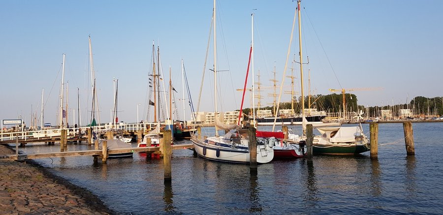 Marina w Travemünde o zachodzie słońca, liczne maszty jachtów żaglowych przy nabrzeżu