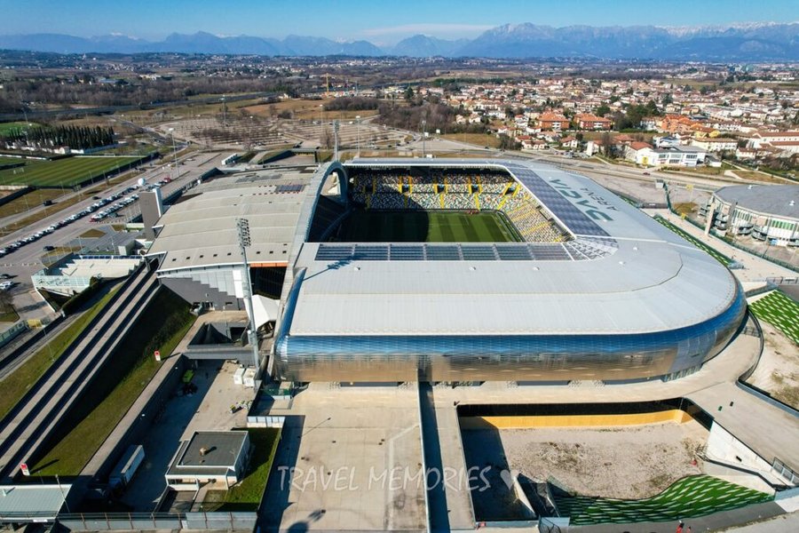Stadion Dacia Arena w Udine widziany z drona z panoramą miasta i Alp w tle