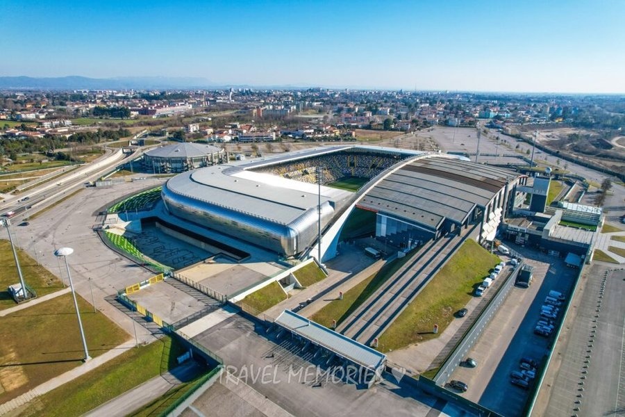 Stadion Dacia Arena w Udine widziany z drona z boku, widoczna okoliczna zabudowa miasta