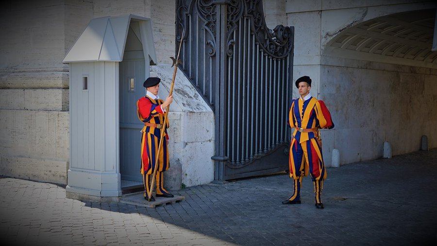 Gwardziści szwajcarscy w charakterystycznych, historycznych uniformach przy bramie Watykanu